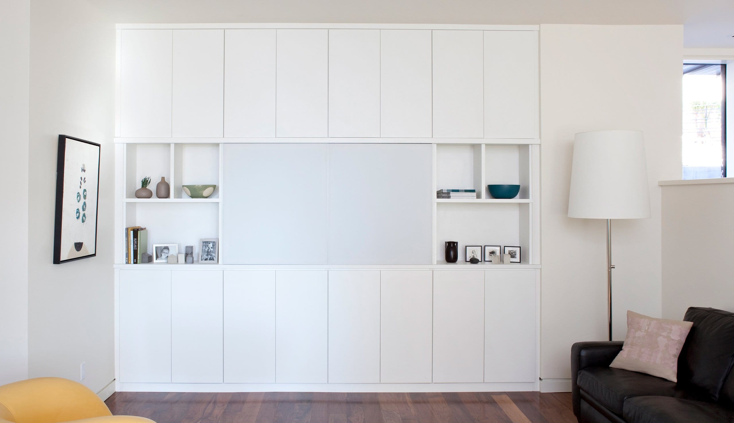 After a professional installation of an entertainment center with custom storage cabinets, shelving and television shelf created by California Closets